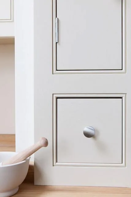 Close-up of a hand-painted shaker drawer front with a polished silver knob